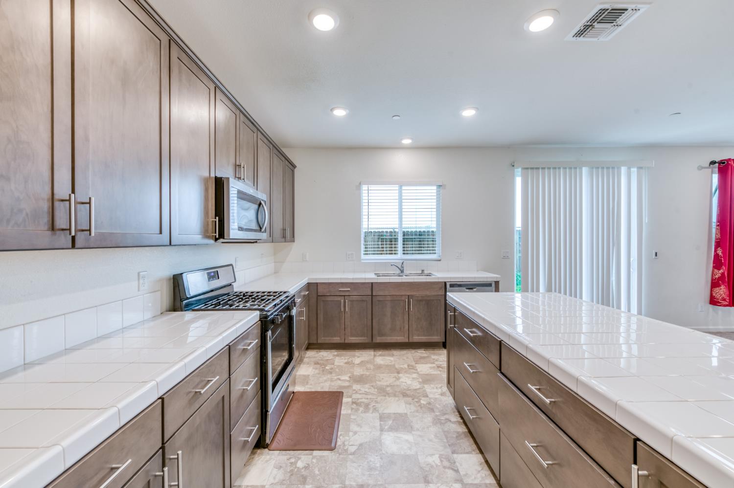 1469 Rinconada Drive Madera, CA 93637 - Photo 12 of 32 a large kitchen with stainless steel appliances granite countertop a sink stove and cabinets
