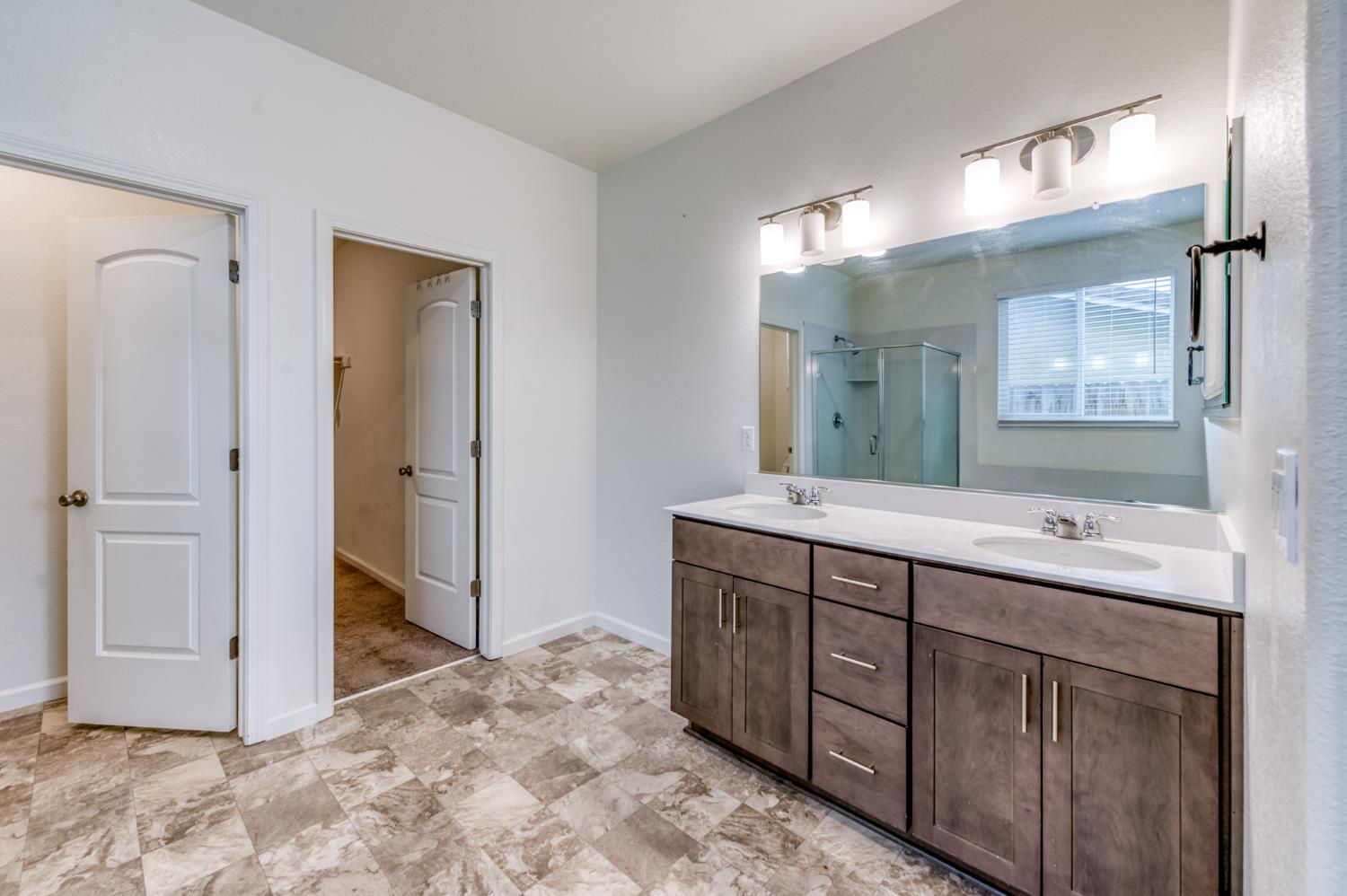 1469 Rinconada Drive Madera, CA 93637 - Photo 7 of 32 a bathroom with a double vanity sink and a mirror