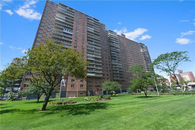 a view of a large building with a big yard and large trees