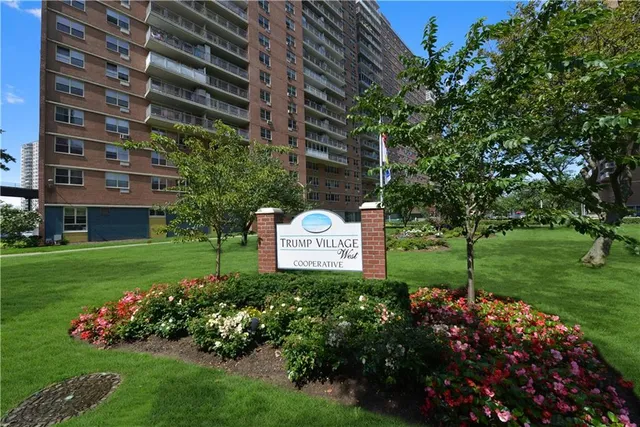 a sign that is sitting in the grass near a tree