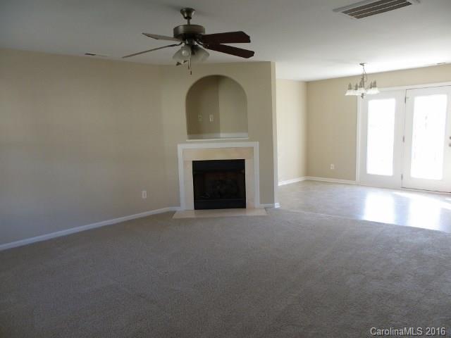 720 Jones Branch Road Fort Mill, SC 29715 - Photo 2 of 12 an empty room with windows fireplace and fan
