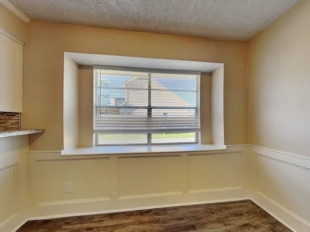 a large kitchen with granite countertop a sink and cabinets