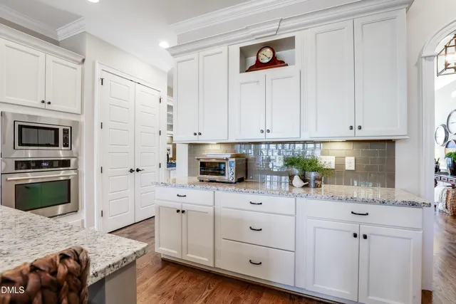 a kitchen with white cabinets and appliances
