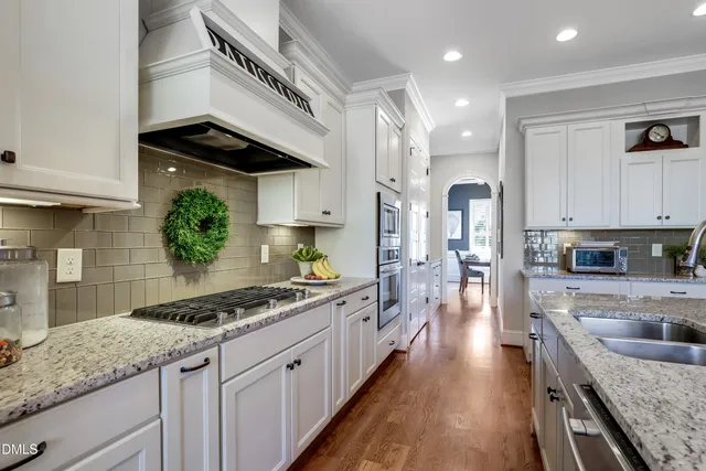 a kitchen with stainless steel appliances granite countertop a sink stove and refrigerator