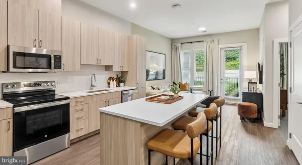 a kitchen with a stove a sink a microwave a dining table and chairs