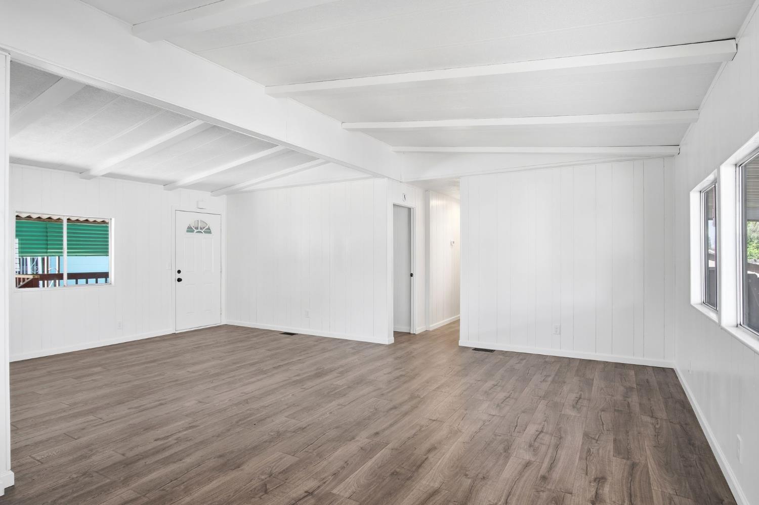 1200 South Carpenter Road, Unit 10 Modesto, CA 95351 - Photo 6 of 27 an empty room with wooden floor and windows