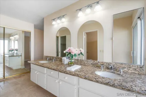 a bathroom with a granite countertop sink a mirror and a shower