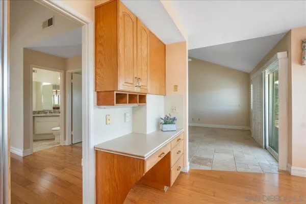 a large white kitchen with a large window a sink and stainless steel appliances