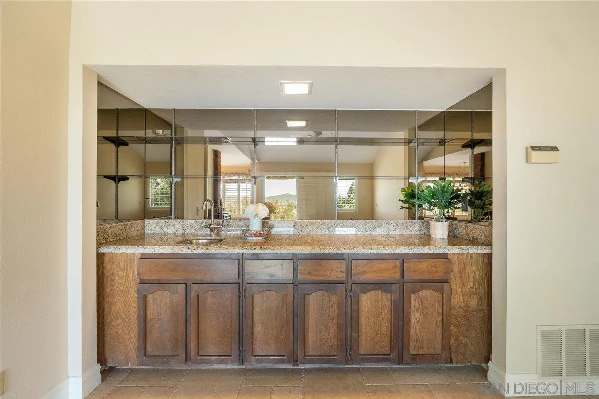 17526 St Andrews Drive Poway, CA 92064 - Photo 31 of 55 a bathroom with a granite countertop sink and a mirror
