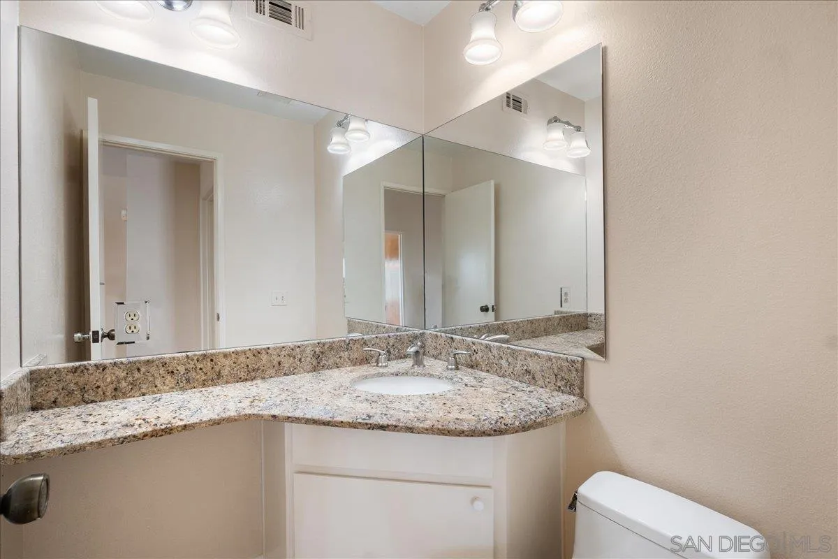 17526 St Andrews Drive Poway, CA 92064 - Photo 32 of 55 a bathroom with a granite countertop sink and a mirror