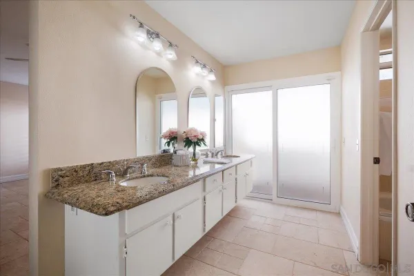 a bathroom with a granite countertop sink and a mirror