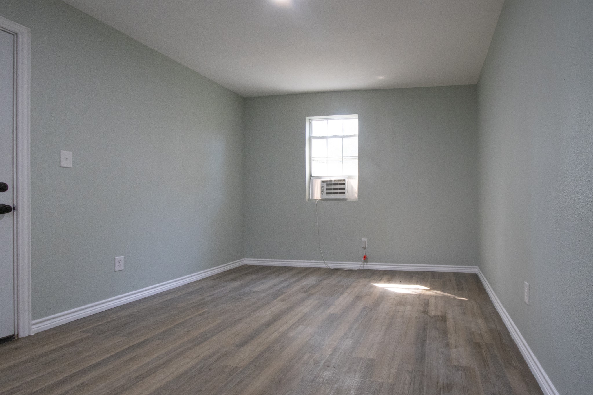 229 Bishop Street, Unit 10 Livingston, TX 77351 - Photo 2 of 14 a view of an empty room with wooden floor and a window
