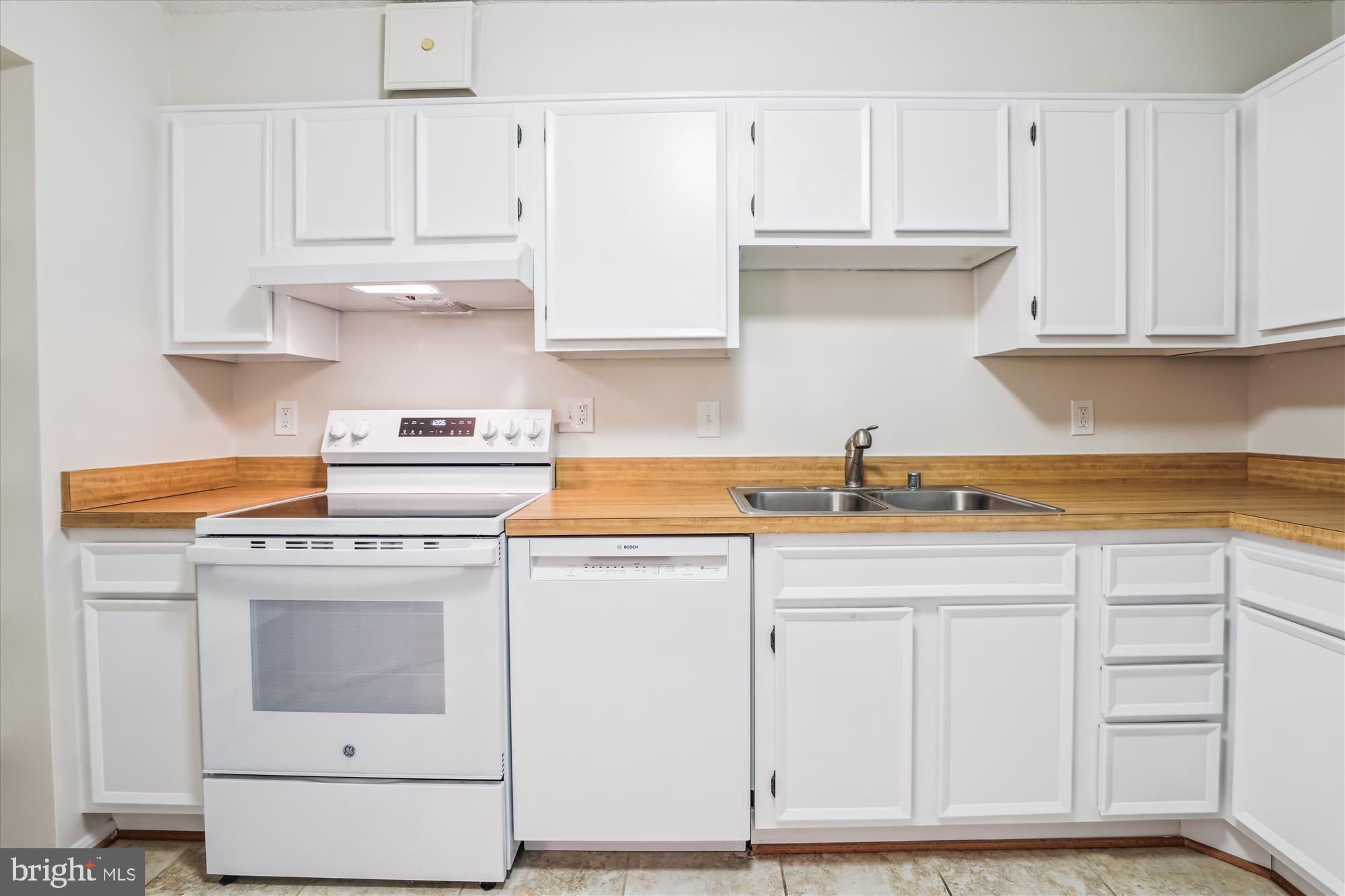 5904 Mt Eagle Drive, Unit 1109 Alexandria, VA 22303 - Photo 12 of 43 a kitchen with granite countertop white cabinets and white appliances
