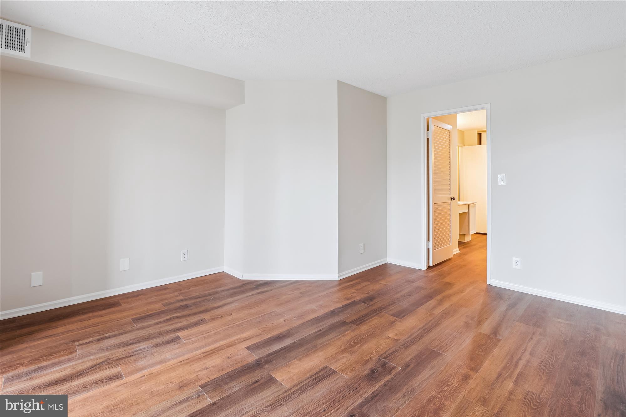 5904 Mt Eagle Drive, Unit 1109 Alexandria, VA 22303 - Photo 14 of 43 a view of an empty room with wooden floor and a window