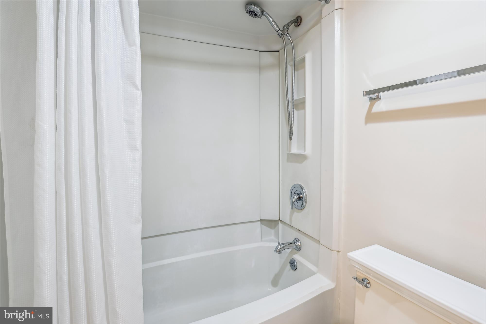 5904 Mt Eagle Drive, Unit 1109 Alexandria, VA 22303 - Photo 18 of 43 a white bath tub with a shower curtain