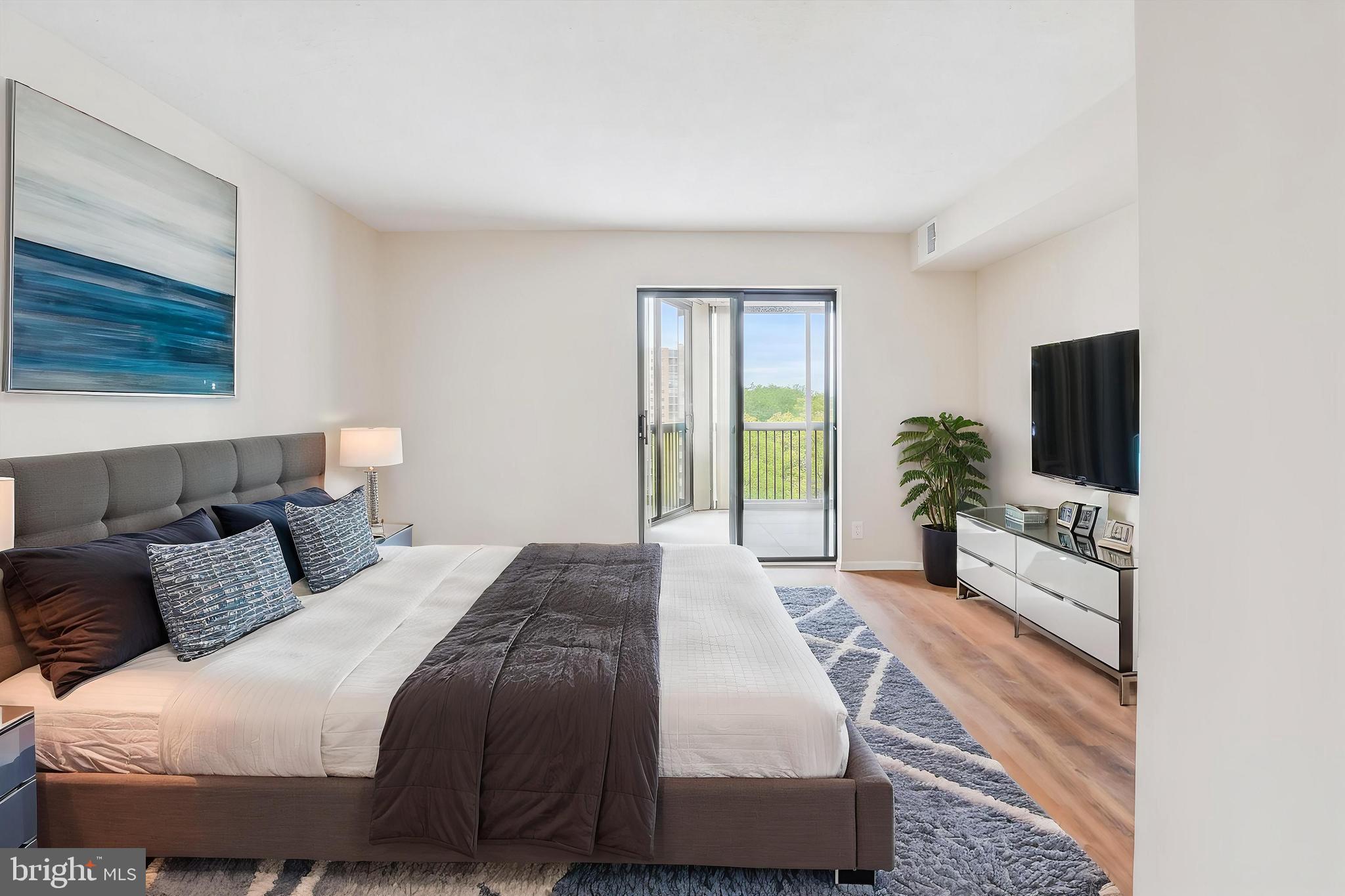 5904 Mt Eagle Drive, Unit 1109 Alexandria, VA 22303 - Photo 4 of 43 a bedroom with a bed and a flat screen tv