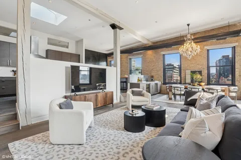 a living room with furniture a chandelier and a flat screen tv