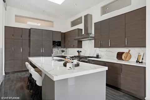a kitchen with a sink a stove and chairs