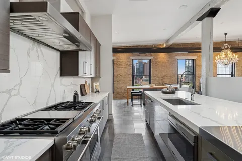 a kitchen with stainless steel appliances granite countertop a sink stove and cabinets