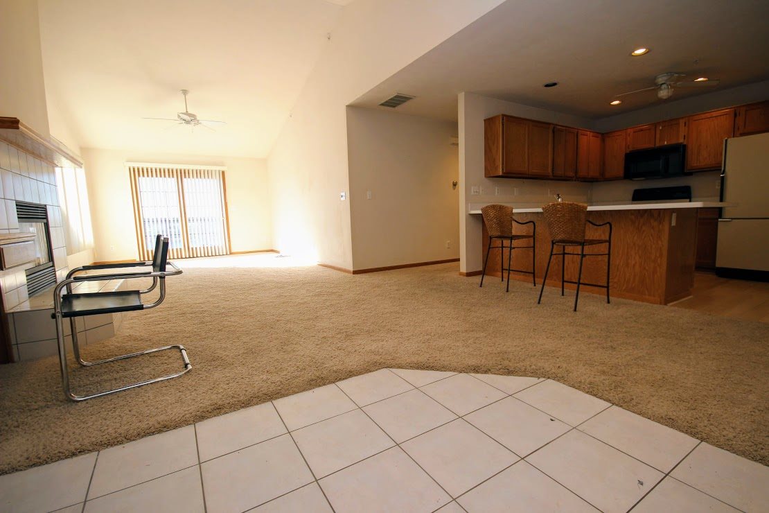 7260 North Alpine Road, Unit 3 Loves Park, IL 61111 - Photo 4 of 14 a kitchen with stainless steel appliances kitchen island granite countertop a stove a sink a microwave a dining table and chairs with white cabinets