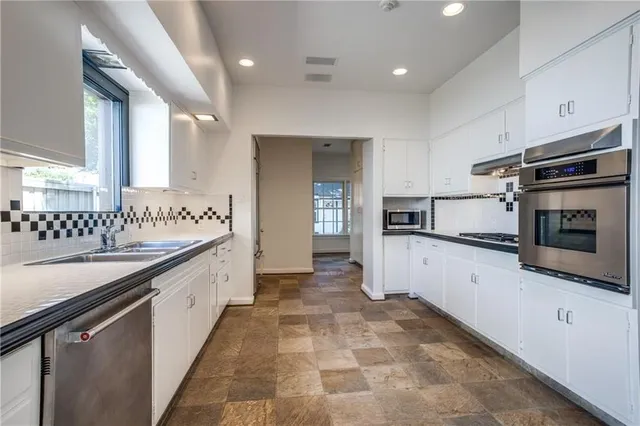 a kitchen with granite countertop a sink and cabinets