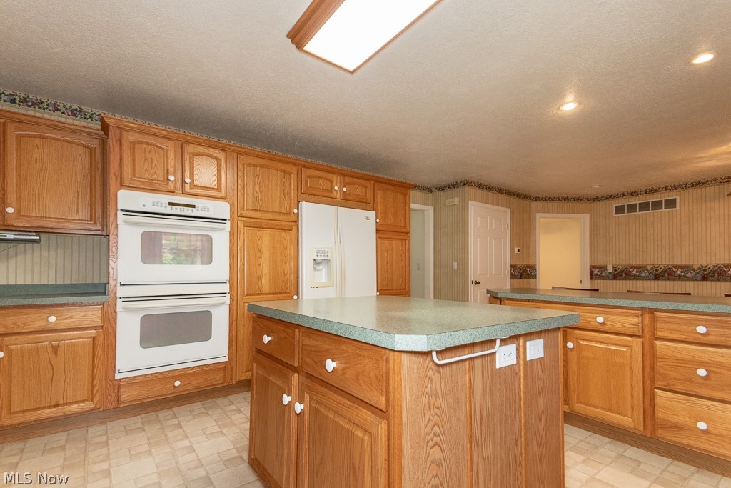 7710 Brakeman Road Painesville, OH 44077 - Photo 8 of 34 Kitchen featuring light tile patterned flooring, a center island, and white appliances