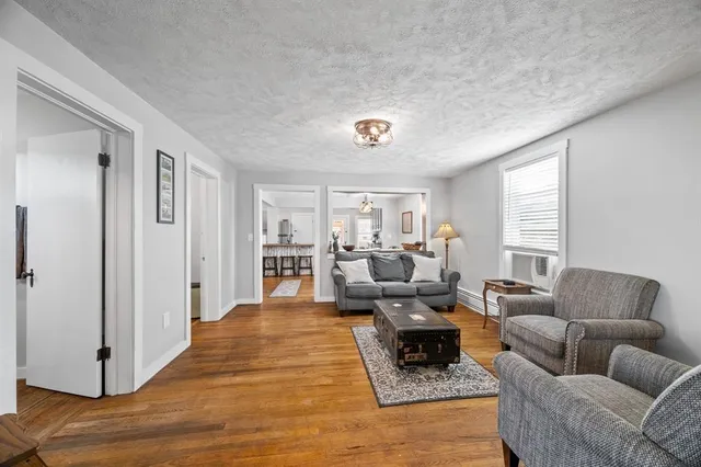 a living room with furniture wooden floor and window