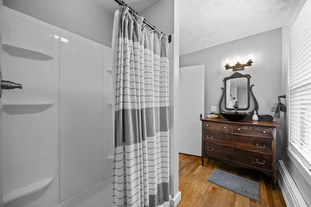 a bathroom with a sink a mirror and shower