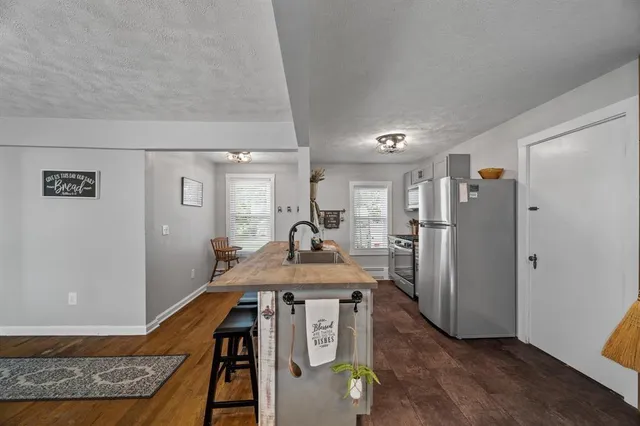 a view of a kitchen with furniture and a refrigerator