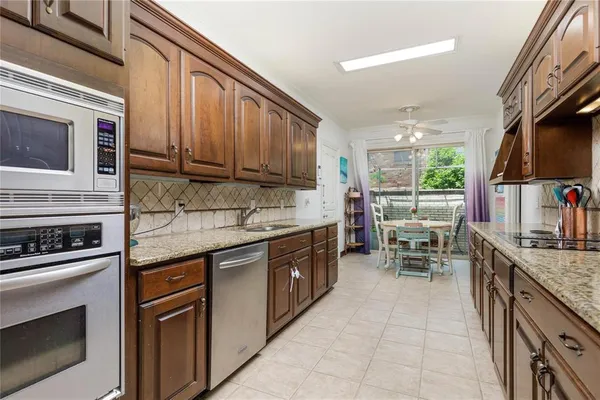 a kitchen with stainless steel appliances granite countertop a stove top oven microwave and a sink