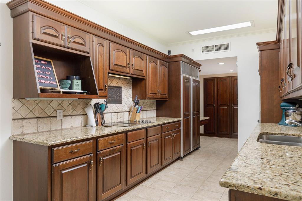 6126 Averill Way, Unit 103W Dallas, TX 75225 - Photo 16 of 34 a kitchen with stainless steel appliances granite countertop a sink stove and refrigerator