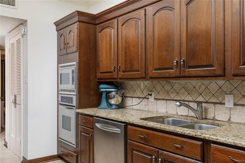 6126 Averill Way, Unit 103W Dallas, TX 75225 - Photo 17 of 34 a kitchen with stainless steel appliances granite countertop a sink a refrigerator and cabinets