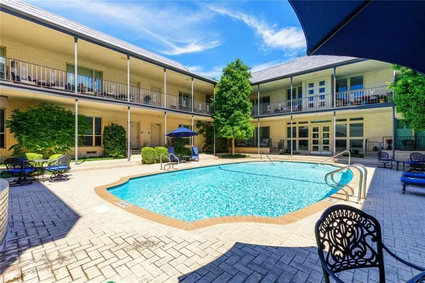 a view of a house with a swimming pool and sitting area