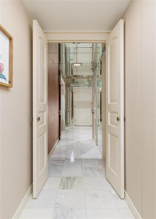 6126 Averill Way, Unit 103W Dallas, TX 75225 - Photo 6 of 34 a view of a hallway with wooden shelves