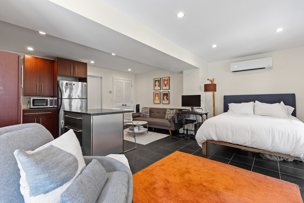 62 Grampian Way, Unit STUDIO Boston, MA 02125 - Photo 1 of 25 a bed room with furniture and a flat screen tv