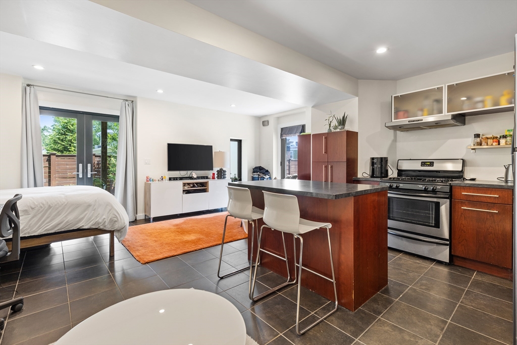 62 Grampian Way, Unit STUDIO Boston, MA 02125 - Photo 12 of 25 a living room with stainless steel appliances furniture and a flat screen tv