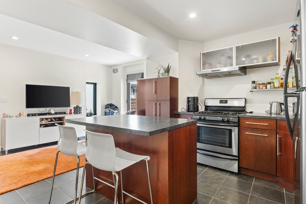 62 Grampian Way, Unit STUDIO Boston, MA 02125 - Photo 13 of 25 a kitchen with stainless steel appliances a stove refrigerator sink and cabinets