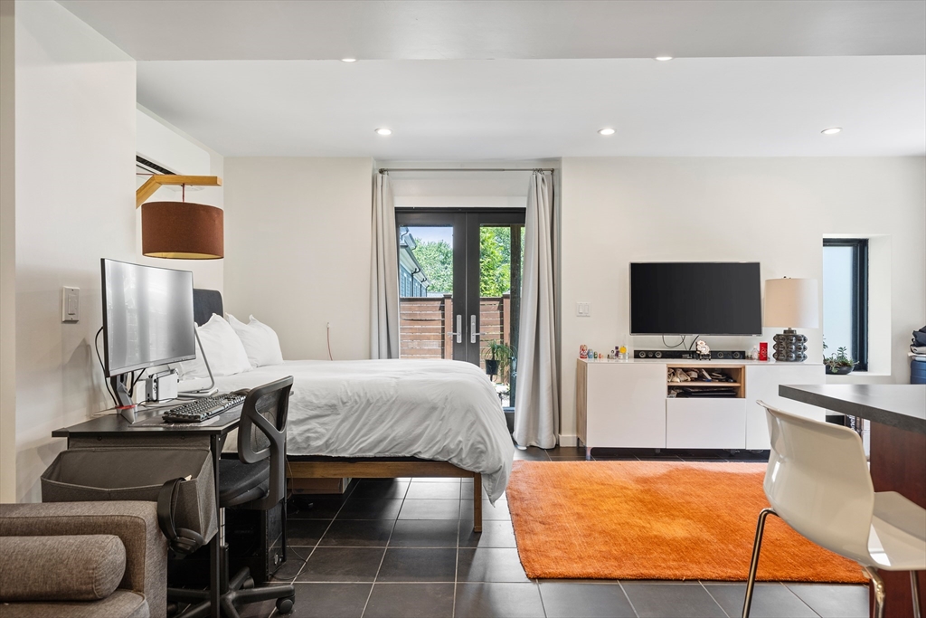 62 Grampian Way, Unit STUDIO Boston, MA 02125 - Photo 14 of 25 a bedroom with furniture and a flat screen tv