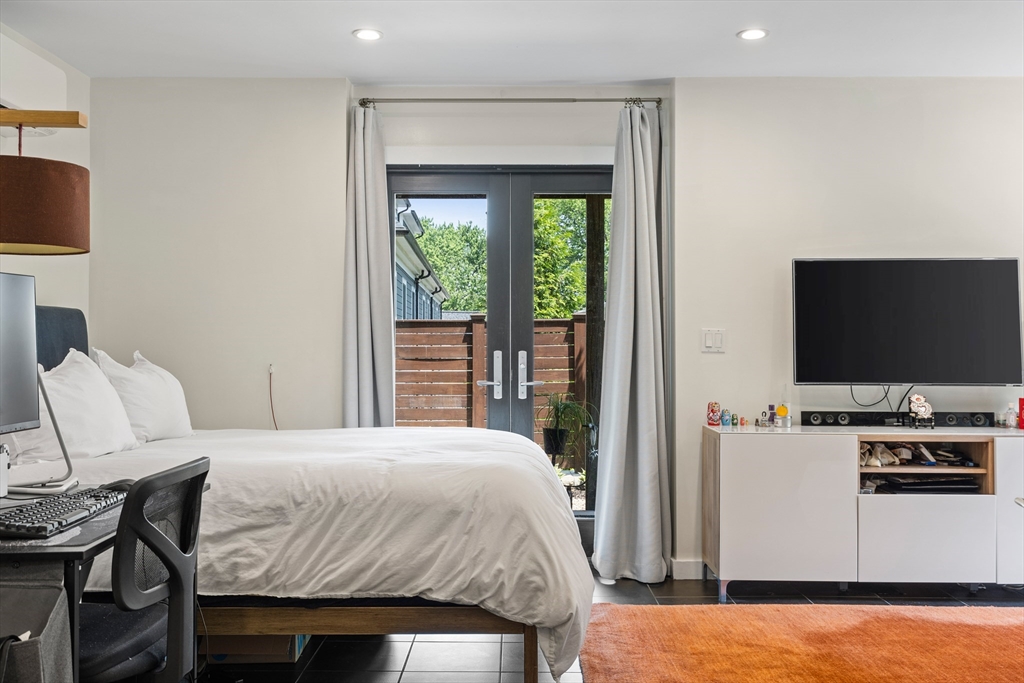 62 Grampian Way, Unit STUDIO Boston, MA 02125 - Photo 15 of 25 a bedroom with a bed tv and chair