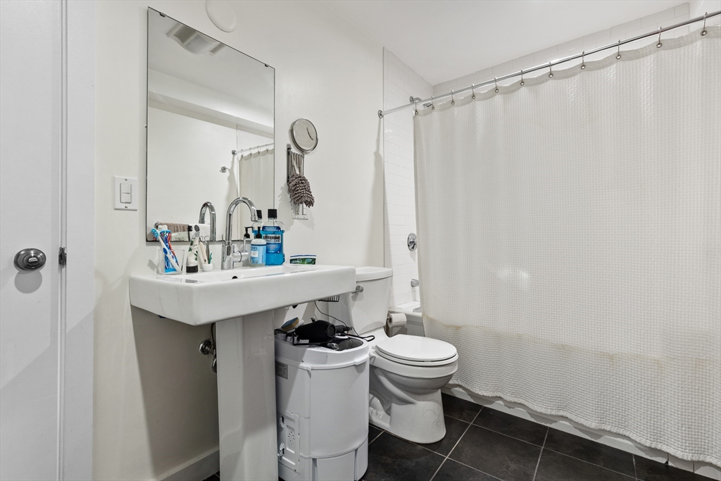 62 Grampian Way, Unit STUDIO Boston, MA 02125 - Photo 18 of 25 a bathroom with a sink toilet and shower