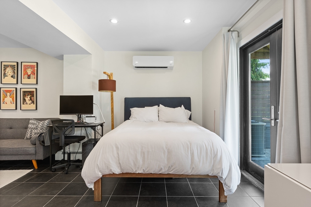 62 Grampian Way, Unit STUDIO Boston, MA 02125 - Photo 3 of 25 a bedroom with a bed and a flat screen tv