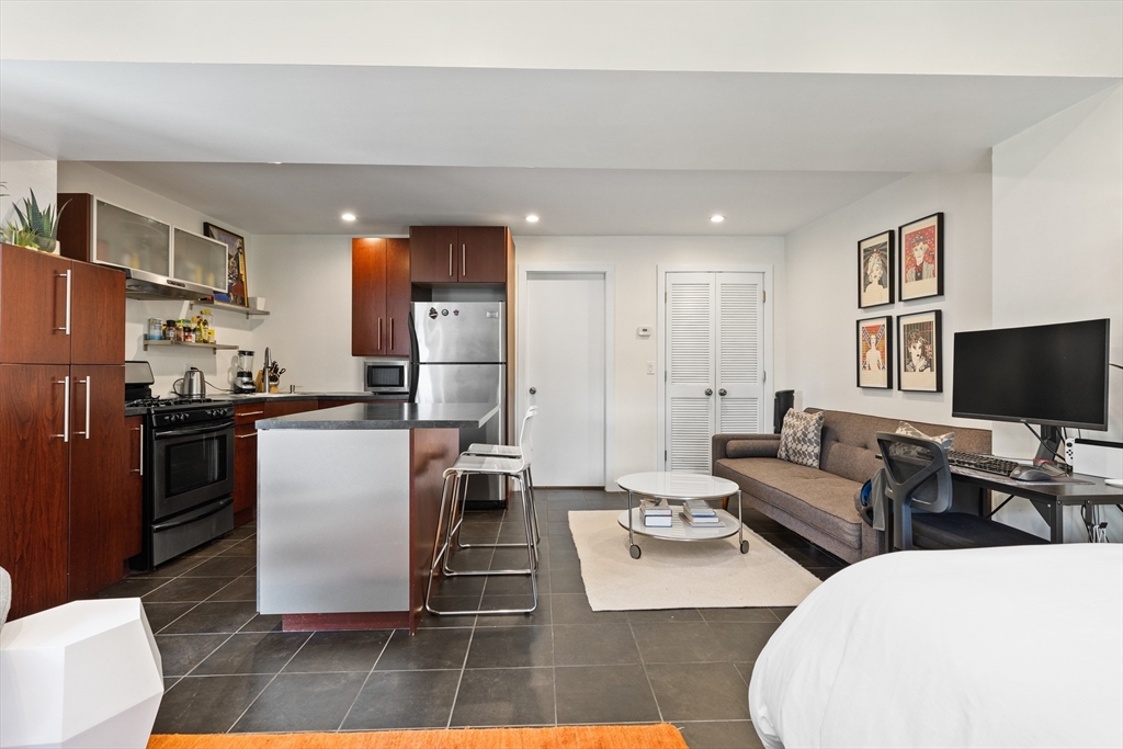 62 Grampian Way, Unit STUDIO Boston, MA 02125 - Photo 7 of 25 a living room with fireplace furniture and a flat screen tv