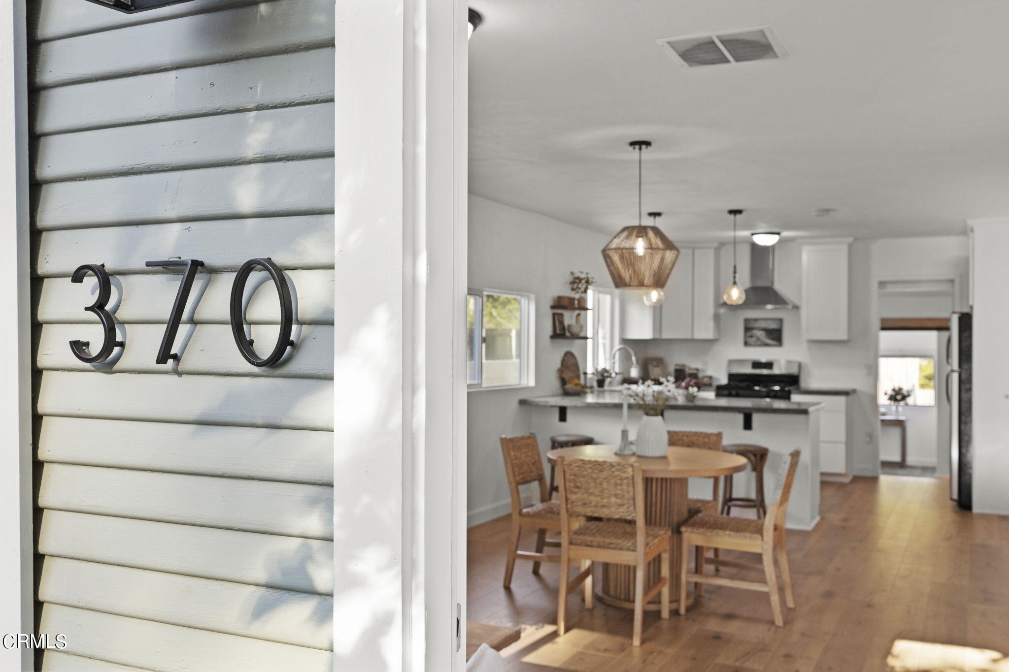 370 Prospect Street Oak View, CA 93022 - Photo 4 of 46 a kitchen with kitchen island granite countertop a stove a oven a dining table and chairs with wooden floor
