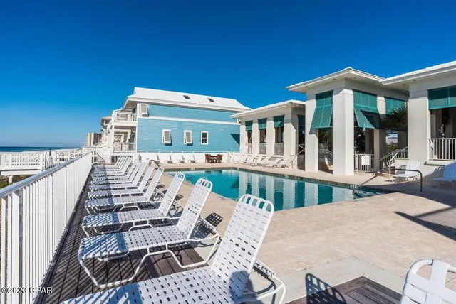 a view of a patio with couches table and chairs with wooden floor and fence