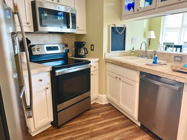 a kitchen with stainless steel appliances granite countertop a stove microwave and sink