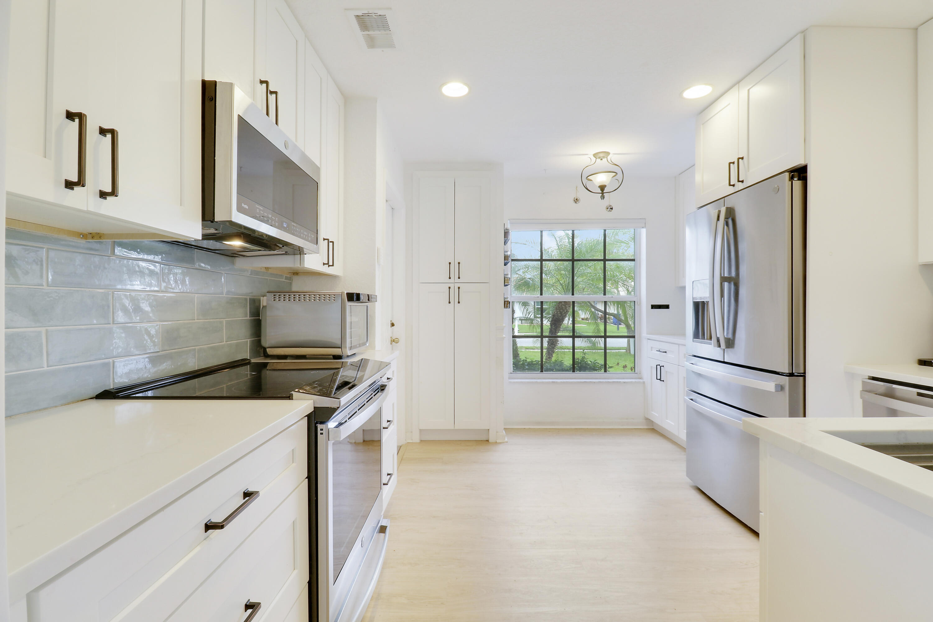 144 Pennock Landing Circle Jupiter, FL 33458 - Photo 12 of 34 a kitchen with a refrigerator a stove top oven a sink and dishwasher