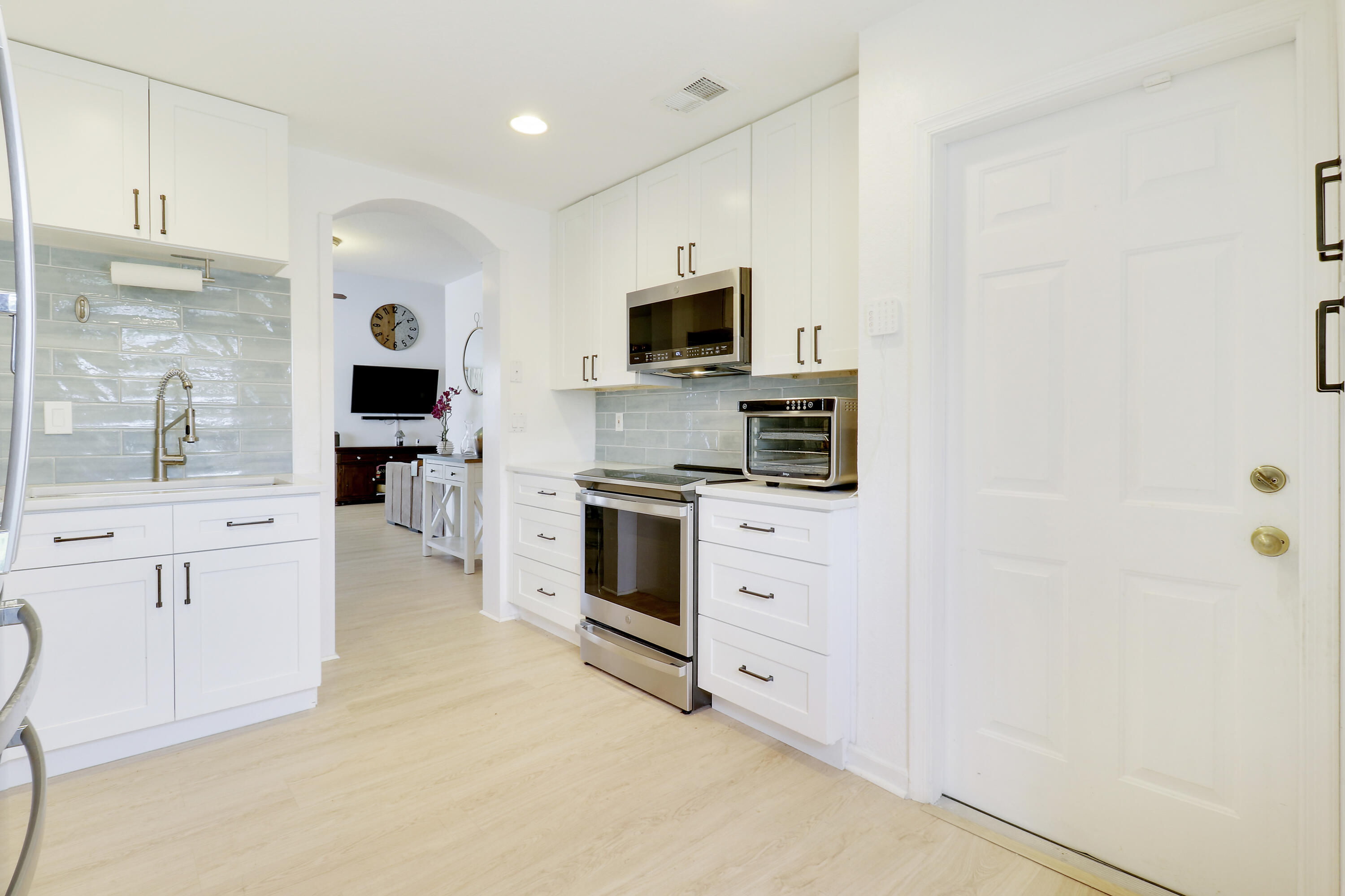 144 Pennock Landing Circle Jupiter, FL 33458 - Photo 15 of 34 a kitchen with stainless steel appliances a white stove top oven a sink and a refrigerator with wooden floor