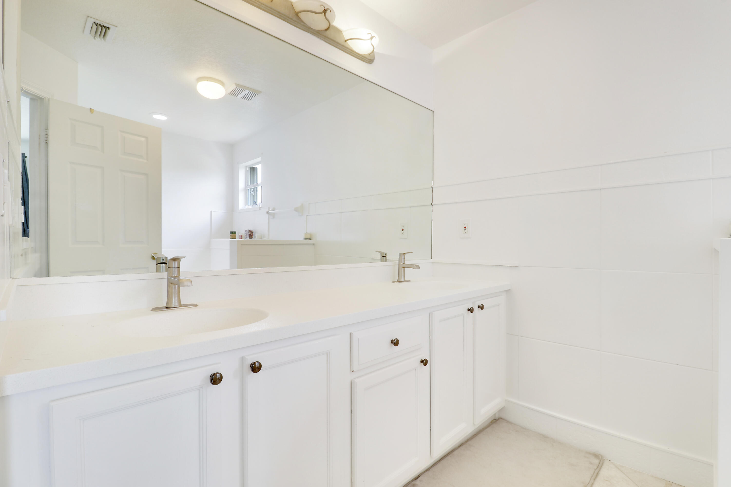 144 Pennock Landing Circle Jupiter, FL 33458 - Photo 21 of 34 a bathroom with a sink vanity and a mirror