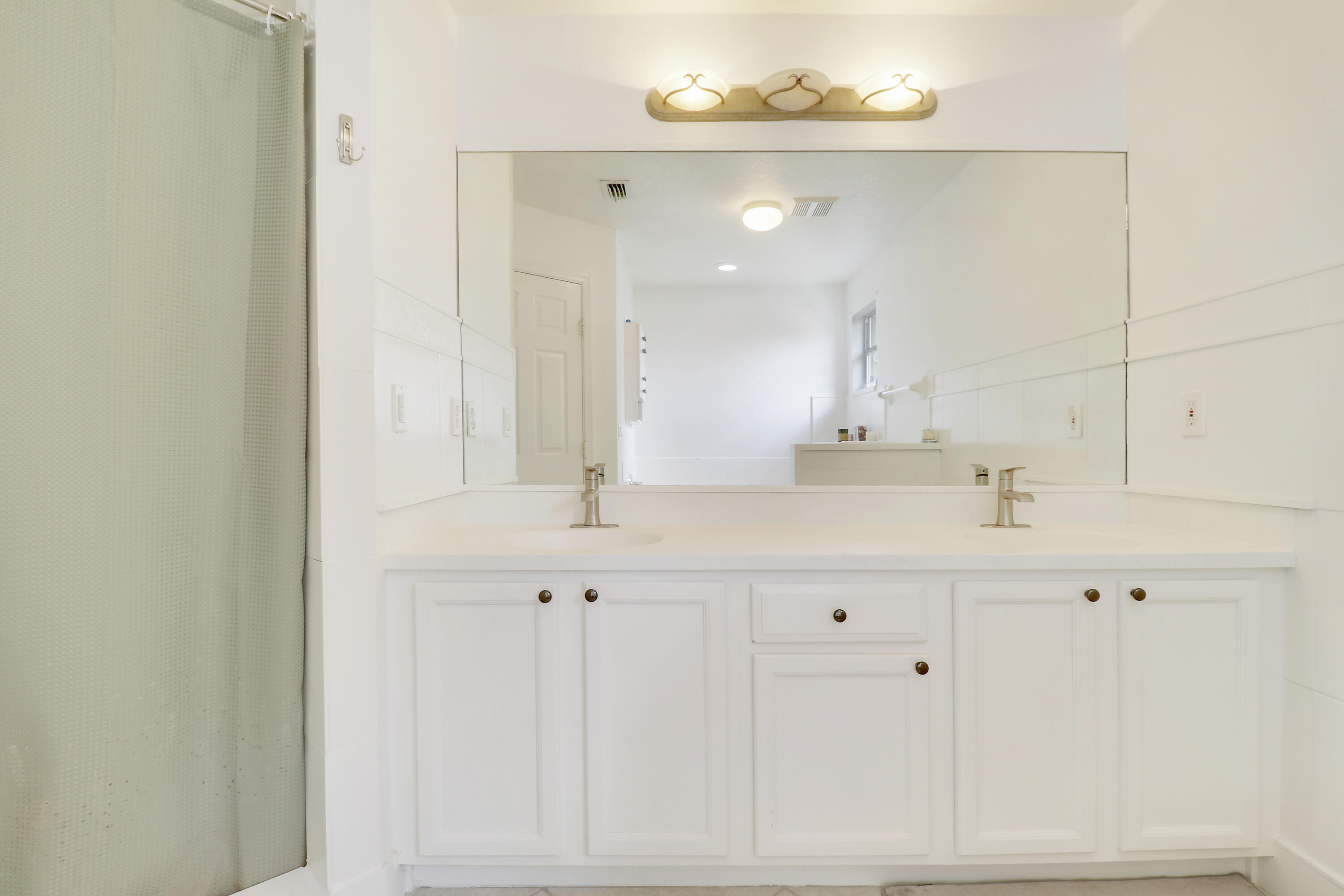 144 Pennock Landing Circle Jupiter, FL 33458 - Photo 23 of 34 a bathroom with a sink vanity and a mirror