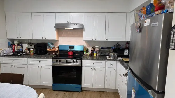 a kitchen with stainless steel appliances granite countertop a stove a refrigerator and a cabinets